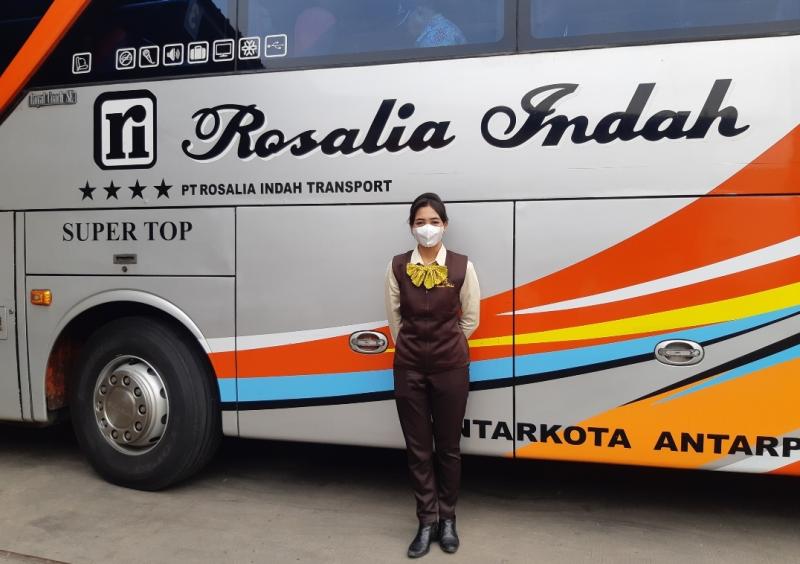 Puri, pramugari bus Rosalia Indah saat bus yang diawakinya sedang manaikkan penumpang di pool bus Bulak Kapal, Bekasi, Kamis (24/3/2022).