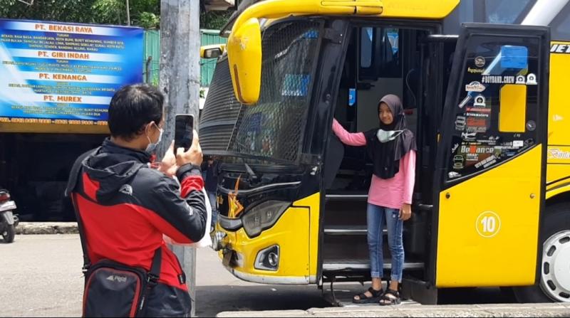 Penumpang sedang berswafoto di bua yang hendak diberangkatkan dari Terminal Bekasi ke Medan, Senin (28/3/2022).