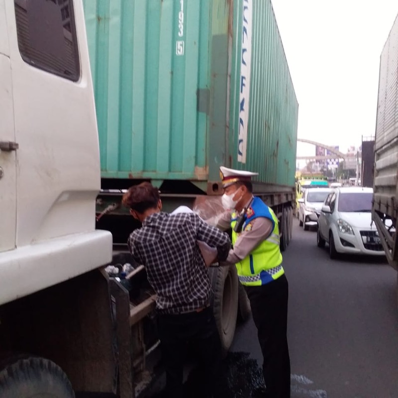 Kanitlantas Bekasi Timur AKP M. Sahari dengan sigap membantu sopir dan kernet truk trailer yang habis solar di Jalan HM Joyomartono Bekasi Timur, Rabu (30/3/2022). Foto: istimewa.