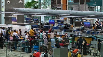 Singapura resmi membuka kembali perbatasan secara penuh pada hari ini, Jumat (1/4), usai dua tahun ditutup akibat pandemi Covid-19. Bandara pun langsung ramai. (AFP/Roslan Rahman)