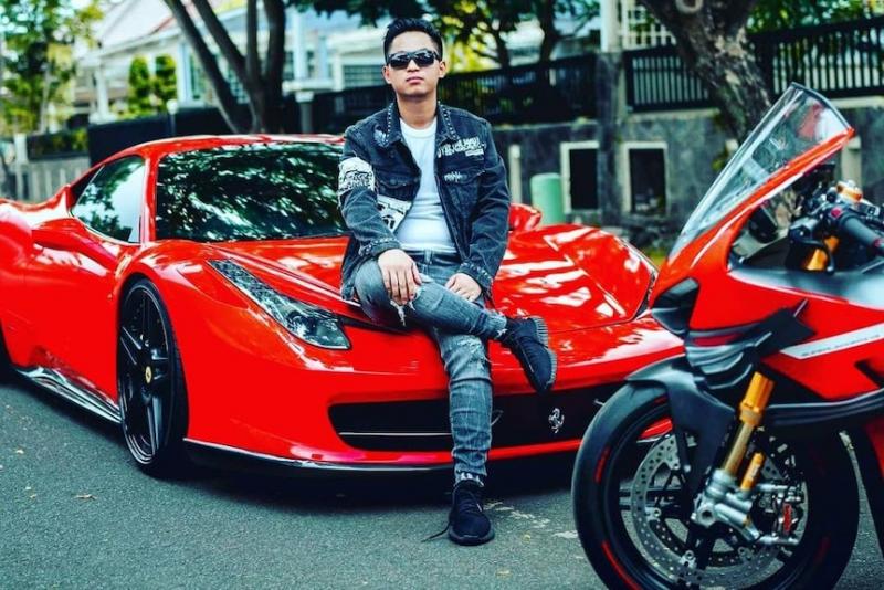 Doni Salmanan berpose di atas kendaraan mewah yang diduga dihasilkan dari menjadi afiliator platform binary options Quotex.(Supplied: Instagram @donisalmanan_real)