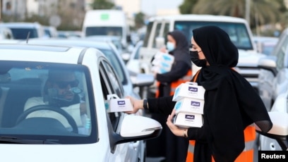 Para sukarelawan di Riyadh, Arab Saudi, membagikan makanan berbuka puasa selama bulan suci Ramadan, 3 April 2022.(REUTERS/Ahmed Yosri)