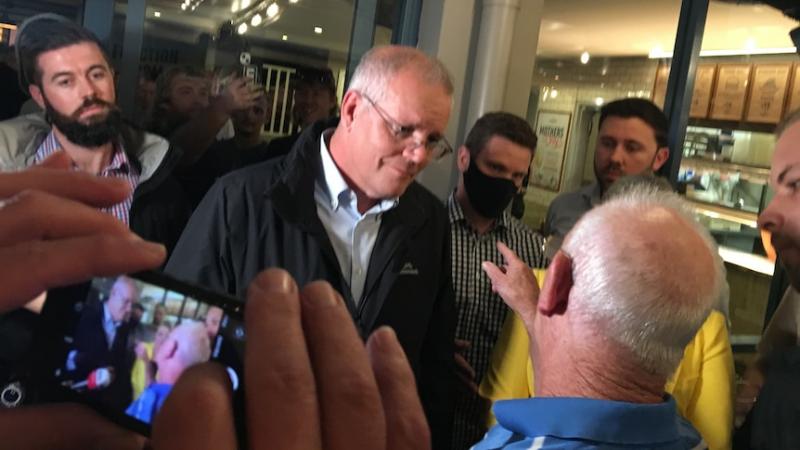 PM Scott Morrison saat mendapat kecaman dari seorang pensiun di sebuah pub di kawasan Newcastle, Rabu malam (6/04).(ABC News: Blake Doyle)