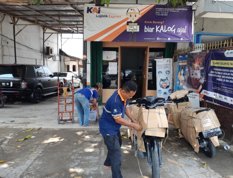 Seorang porter sedang mengemas sepeda motor yang akan diangkut menggunakan jasa dari KAI Logistik Cabang Bekasi, Jawa Barat, Jumat (15/4/2022). 