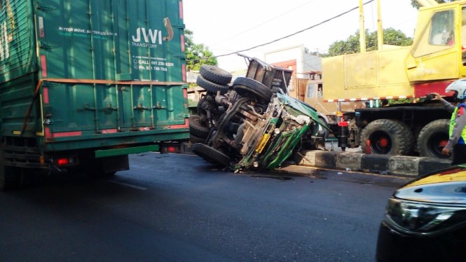 Truk trailer terguling di tengah jalan usai menabrak 5 kendaraan sehingga  menghalangi kendaraan lain.  (Foto:tvonenews.com)