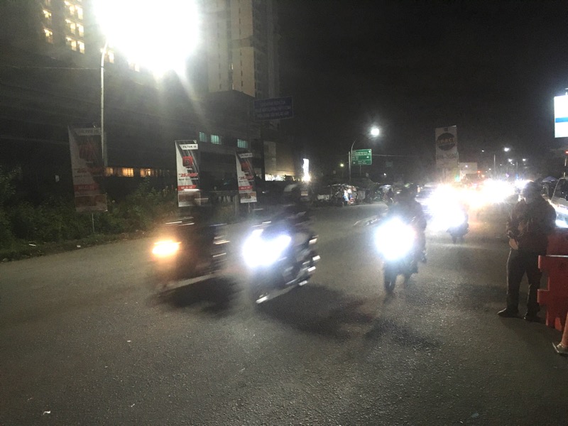 Pemudik menggunakan sepeda motor melintas di depan Pospam Tongyang Bekasi Timur, Kamis (28/4/2022) malam. Foto: BeritaTrans.com.