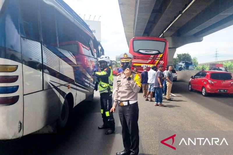 Petugas  mengevakuasi bus mogok di Jalan Tol Jakarta-Cikampek, Kamis (28/04/2022). Foto:ANTARA) 