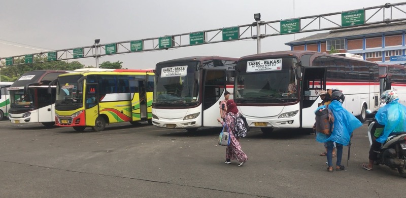 Calon penumpang berjalan di depan bus AKDP di Terminal Bekasi, Selasa (31/5/2022) siang. Foto: BeritaTrans.com.