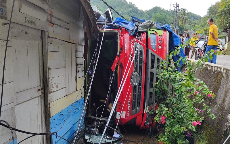 Truk tangki Pertamina BK 9504 SH terguling menimpa bagian depan tiga unit rumah warga di jalan Sibolga-Tarutung, Kelurahan Hutabarangan, Jumat  pagi ( 3/6/2022). (Foto: iNews)