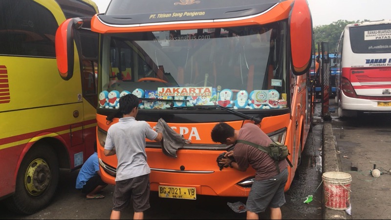 Kru bus TISPA tengah membersihkan unit armadanya di Terminal Bekasi. Foto: BeritaTrans.com.