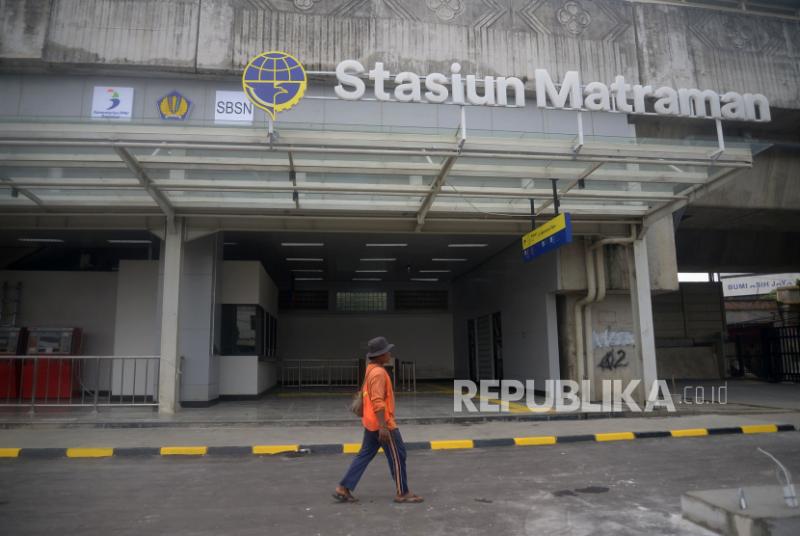 Pekerja berjalan di dekat pintu masuk Stasiun Matraman, Jakarta.
