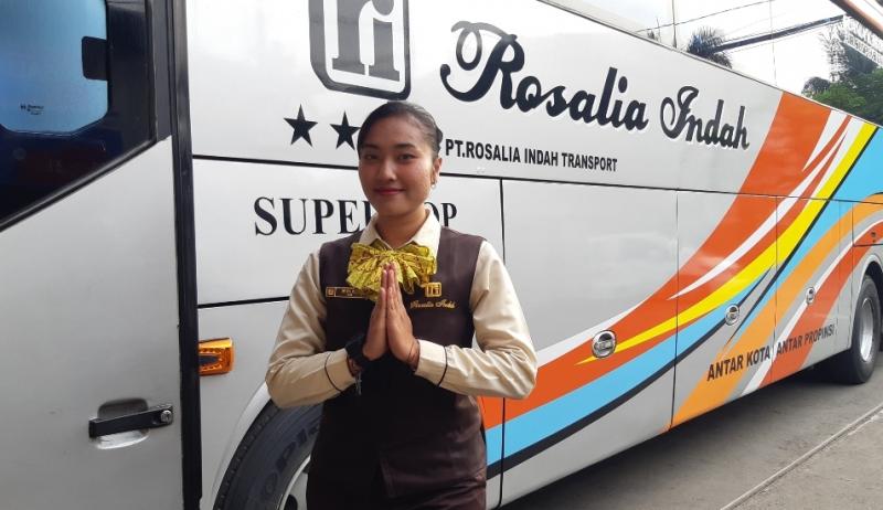 Wulan pramugari bus PO Rosalia Indah saat melayani naik turun penumpang busnya di pool Bulak Kapal, Bekasi.
