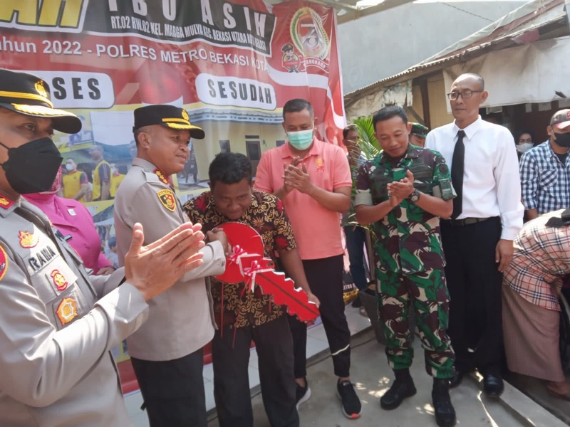 Kapolres Metro Bekasi Kota Kombes Pol Hengki, bersama Plt Wali Kota Tri Adhianto dan Dandim 0507/Bekasi Letkol Kav Luluk Setyanto di momen HUT ke-76 Bhayangkara menyerahkan kunci rumah kepada Ibu Asih dan Keluarga, Jumat (1/7/2022). Foto: istimewa.