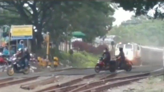 Tangkap layar video yang memperlihatkan tiga pengendara sepeda motor nekat menerobos pintu kereta api di Cimindi, Kota Cimahi, Kamis (30/6/2022). 