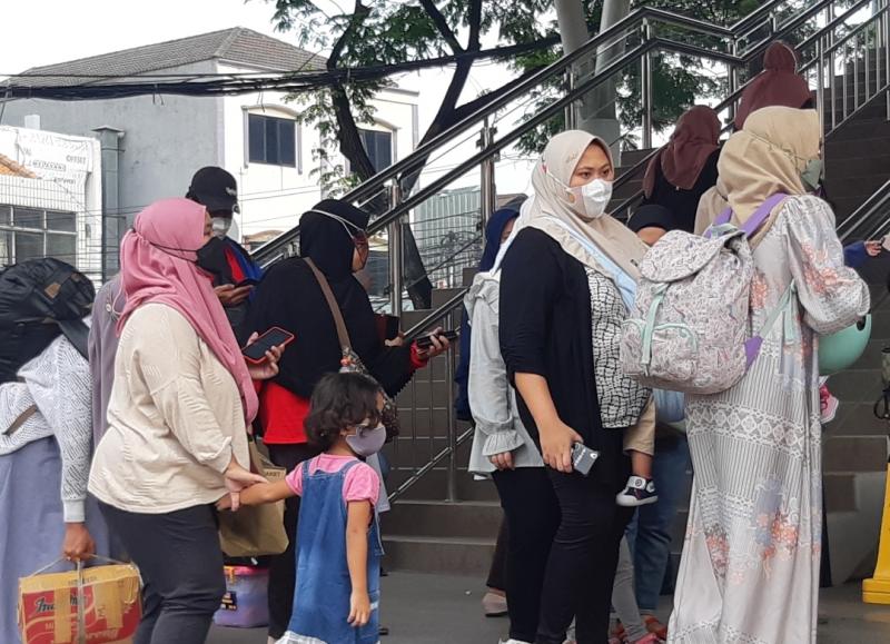 Penumpang yang membawa anak balita menanti jadwal jam masuk Stasiun Bekasi pada pukul 9.00, Senin (11/7/2022).