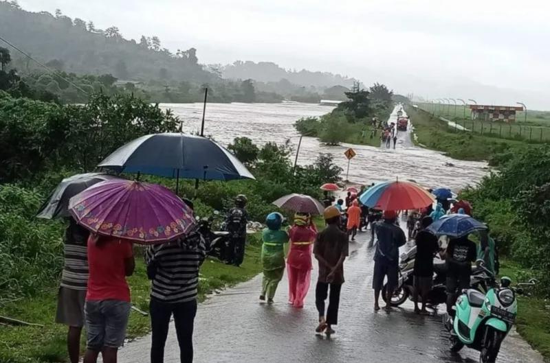 Warga menyaksikan air Sungai Sikula yang meluap dan melewati ruas di dekat Bandara Internasional Pattimura Ambon, Maluku, Selasa (26/7/022). ANTARA/Jimmy Ayal
