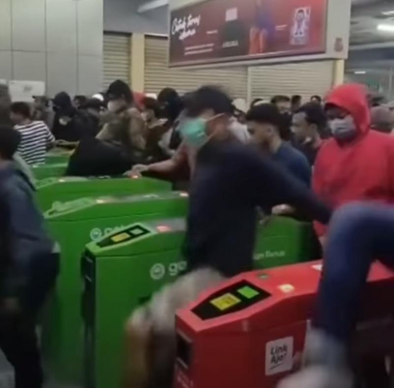 Potongan video yang memperlihatkan suporter bola beramai-ramai masuk melangkahi gate tanpa melakukan tap tiket di Stasiun Manggarai, Ahad (27/7/2022).