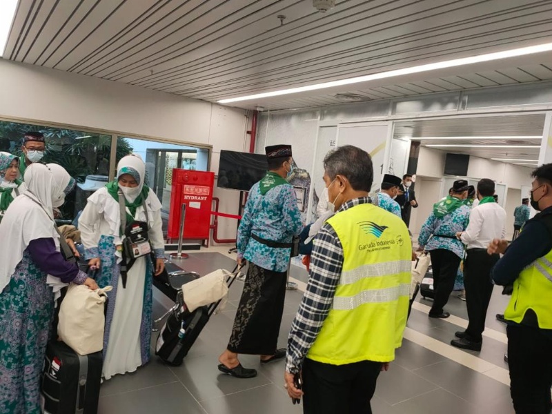 Petugas aambut jemaah haji yang tiba di Bandara Angkasa Pura II