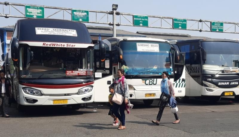 Calon penumpang berjalan di antara bus yang menanti keberangkatan dari Terminal Induk Bakasi, Selasa (23/8/2022).