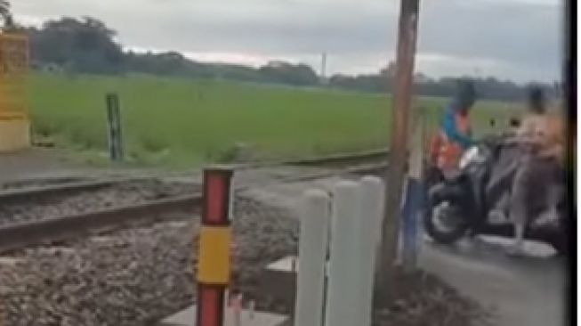 Nyawa pemotor tertolong berkat dihentikan pria yang berdiri di dekat perlintasan kereta api (Instagram)