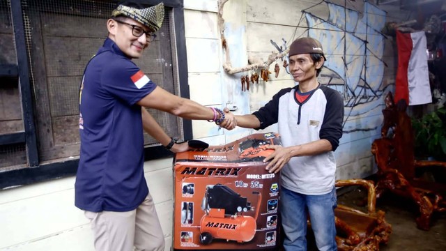 Menparekraf Sandiaga Uno memberikan bantuan mesin kompresor cat kepada Yulis (42), seorang pengrajin kayu di Desa Wisata Tebat Lereh, Pagar Alam, Sumatera Selatan.