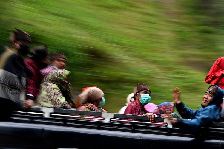 Masyarakat Suku Tengger dengan mengenakan masker berada di mobil bak terbuka menuju kawasan Gunung Bromo untuk melaksanakan perayaan Yadnya Kasada, Probolinggo, Jawa Timur, Senin (6/7/2020). (ANTARA FOTO/ZABUR KARURU)
