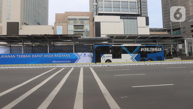 Bus TransJakarta berhenti untuk menaikkan dan menurunkan penumpang di Halte Bundaran HI, Jakarta.