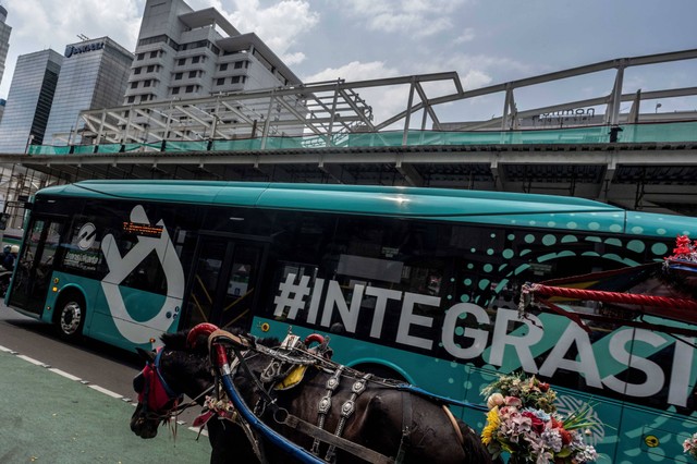 Warga masuk ke dalam bus Transjakarta di Halte TransJakarta Kuningan Barat, Jakarta.