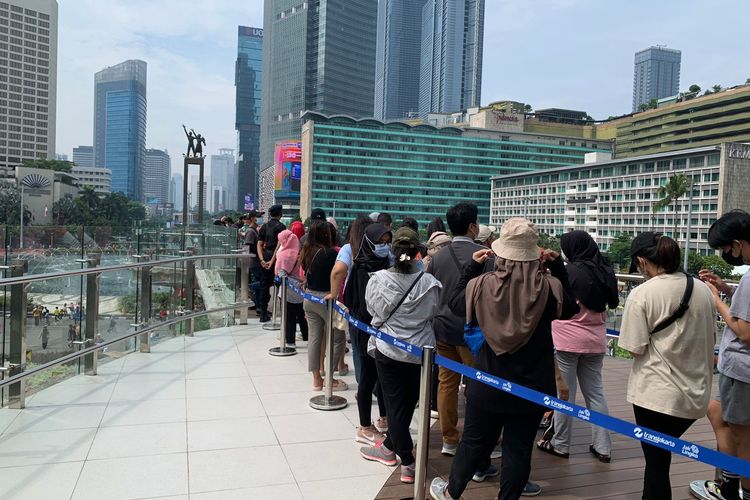 Antrean warga timbul setelah secara bergantian ingin melakukan swafoto berlatar belakang Monumen Selamat Datang dsri Halte Bundaran HI, Jakarta Pusat, Minggu (9/10/2022).(kompas.com/REZA AGUSTIAN )