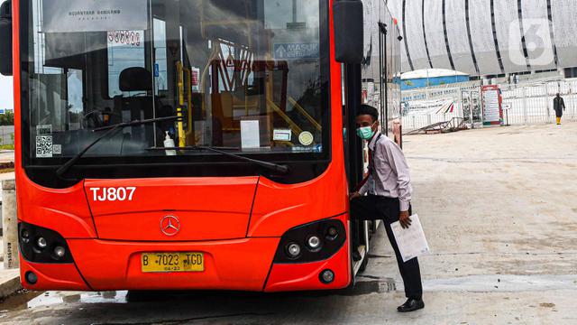 Sopir menaiki bus menunggu penumpang.