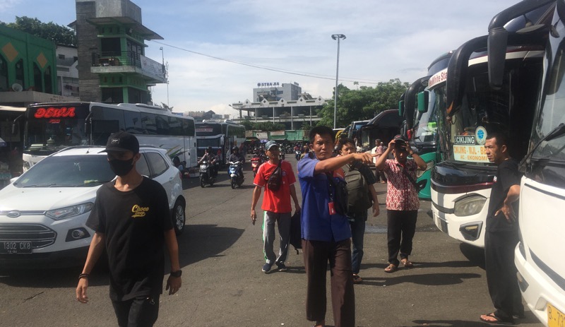 Pengurus bus Primajasa rute Merak tengah mengarahkan penumpang ke bus, Senin (24/10/2022). Foto: BeritaTrans.com.