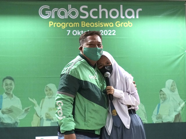 Salah seorang penerima GrabScholar terharu saat berbagi ceritanya bersama sang ayah dalam acara seremoni GrabScholar di Jakarta. 