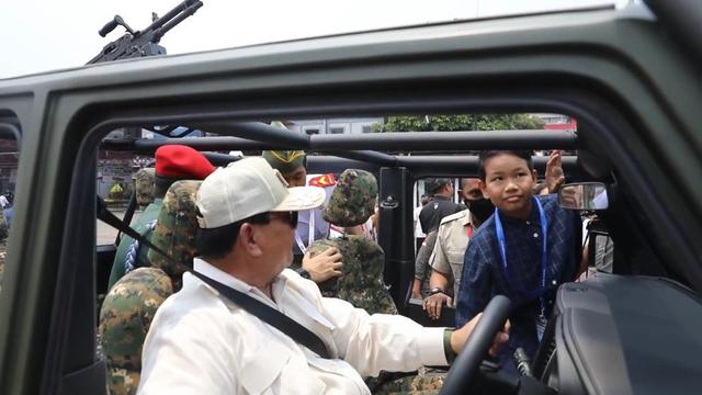 Menteri Pertahanan (Menhan) Prabowo Subianto mengajak anak kecil berkeliling kompleks JIExpo Kemayoran menggunakan kendara taktis