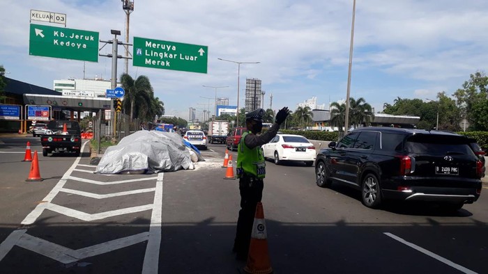 Truk yang memuat pakan ternak terguling usai menabrak pembatas Tol Tomang. 