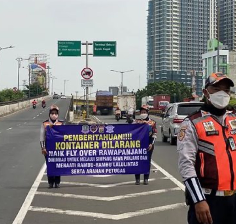 Petugas Dishub Kota Bekasi bentangkan spanduk larangan truk kontainer melintas di Flyover Rawapanjang, Kota Bekasi, Rabu (30/11/2022). Foto: istimewa.
