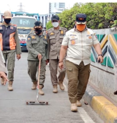 Petugas menyisir jalan di kawasan Senen