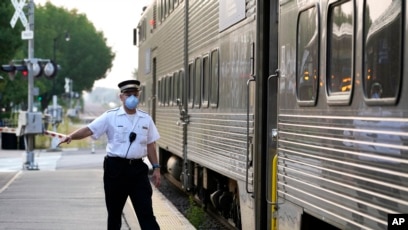 Seorang petugas kereta memberikan sinyal ketika bertugas di stasiun kereta api Arlington Heights di Illinois, pada 15 September 2022. (Foto: AP/Nam Y. Huh)