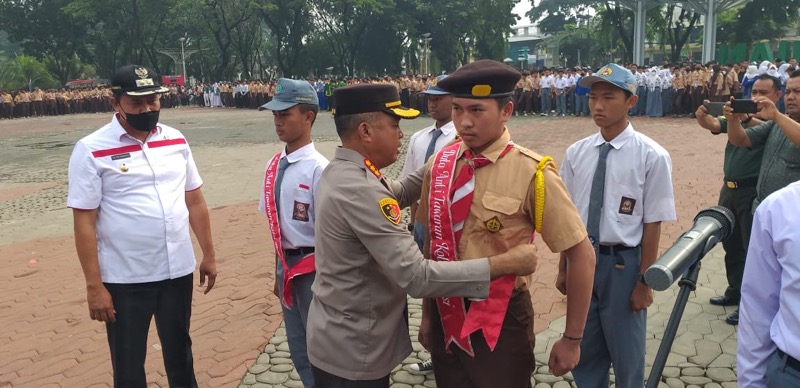 Kapolres Metro Bekasi Kota, Kombes Pol Hengki sematkan selempang ke perwakilan siswa sekolah secara simbolis. Foto: istimewa. 