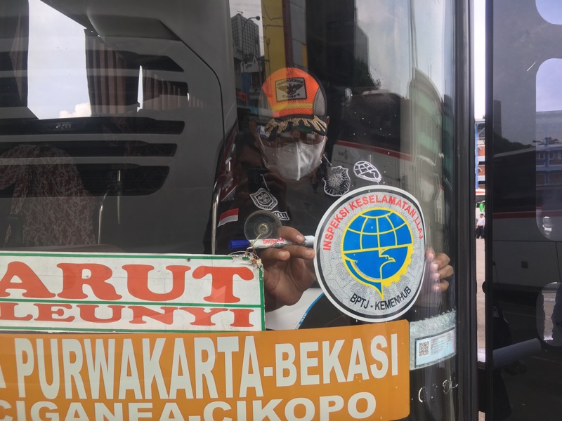 Kepala Seksi (Kasi) Angkutan Dalam Trayek, Permana Sidik tempelkan stiker Inspeksi Keselamatan LLAJ BPTJ-Kemenhub ke bus laik jalan. Foto: BeritaTrans.com. 