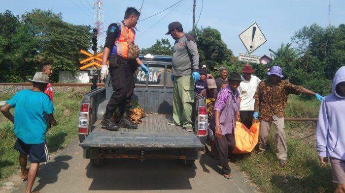 Sejumlah petugas dibantu warga saat mengevakuasi jenazah pasangan suami istri di perlintasan kereta api Kecamatan Kaliwedi, Kabupaten Cirebon, Ahad (11/12/2022).