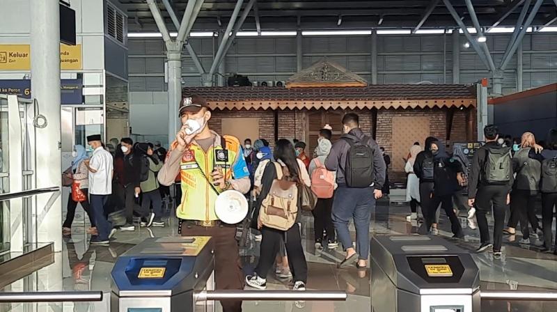 Petugas melakukan pengamanan dan imbauan kepada penumpang KRL di gerbang tap tiket Stasiun Bekasi, Senin (19/12/2022).