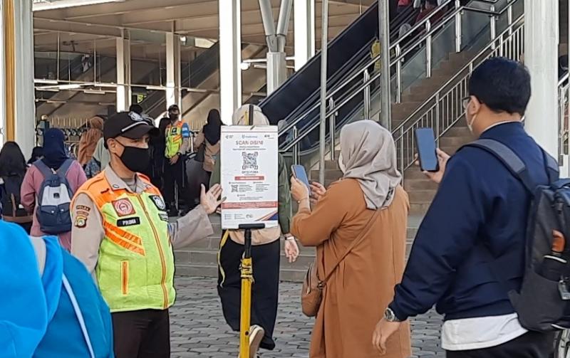 Penumpang melakukan scan kode QR Peduli Lindungi untuk masuk ke Stasiun dan gunakan rangkaian KRL, Senin (19/12/2022). 