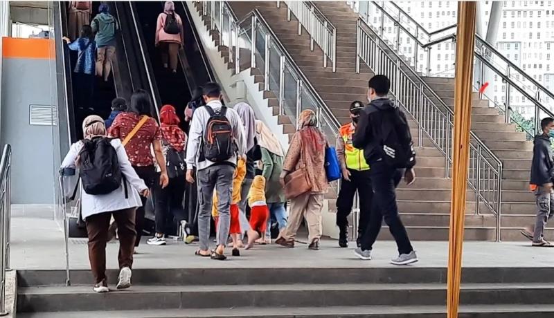 Terlihat seorang penumpang dengan menggunkan tongkat bantu jalan masuk Stasiun Bekasi di antara penumpang lain, Senin (26/12/2022) pagi. 