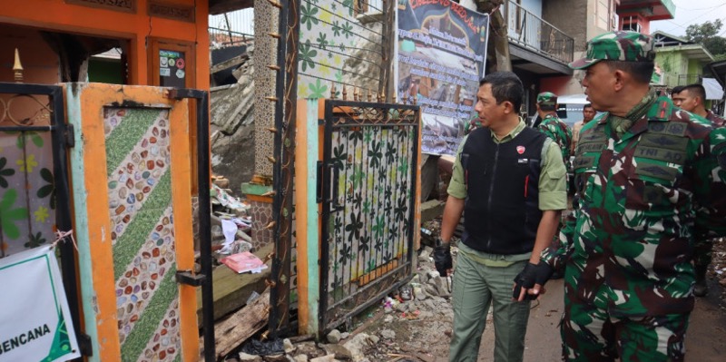 Kepala BNPB Letjen TNI Suharyanto (kemeja hijau dan rompi hitam) meninjau rumah warga terdampak gempa di Kecamatan Gekbrong, Kabupaten Cianjur pada Senin (26/12/2022). Foto: istimewa.