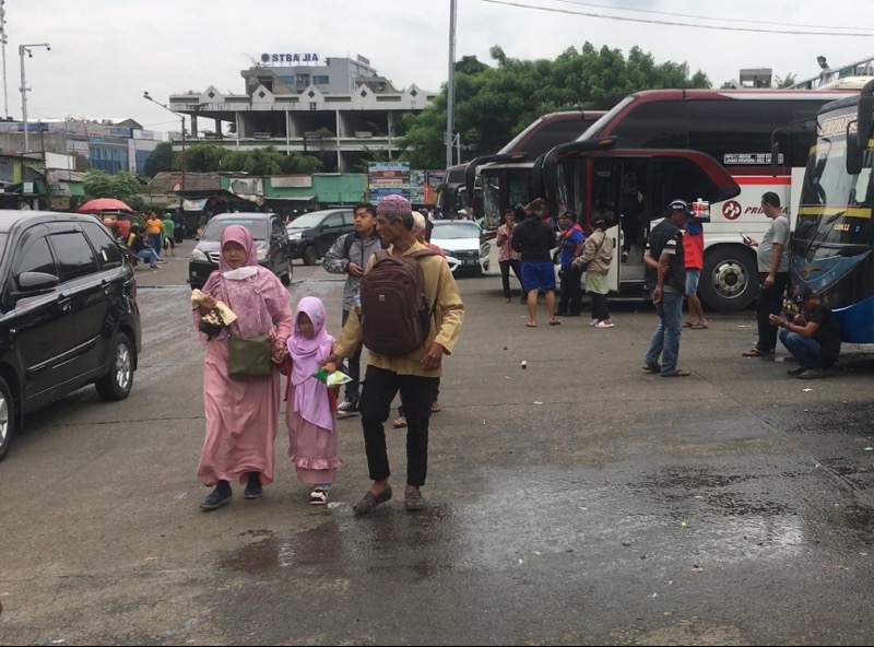 Bocah perempuan berkerudung merah jambu tengah berjalan bersama orang dewasa diantar bus antarkota, Kamis (5/1/2023). Foto: BeritaTrans.com.