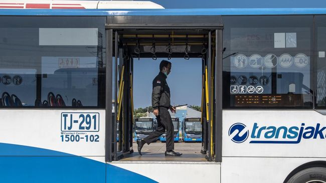 Bus TransJakarta mogok di perlintasan kereta api.