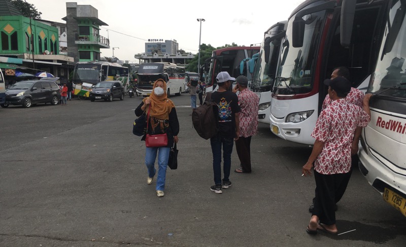 Penumpang berjalan di antara bus antarkota di area keberangkatan Terminal Induk Kota Bekasi, Kamis (2/2/2023).