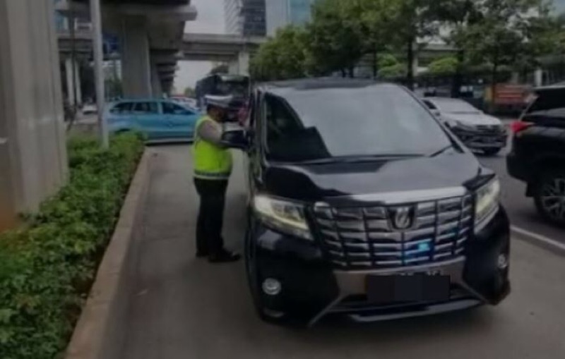 Petugas Polisi lalu lintas menegur kendaraan mewah berjenis Toyota Alphard yang menggunakan Rotator di Jalan Rasuna Said, Kuningan, Jakarta Selatan, Selasa (14/2/2023). Foto: istimewa.