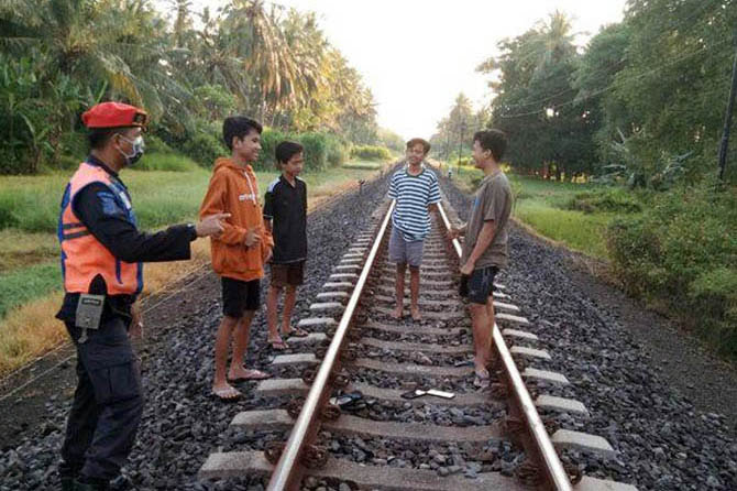 Petugas Polsuska memberi imbauan kepada sejumlah bocah yang nongkrong di perlintasan rel kereta api di Pateguran, Rejoso, beberapa waktu lalu. (Foto: Humas Daop 9 Jember)