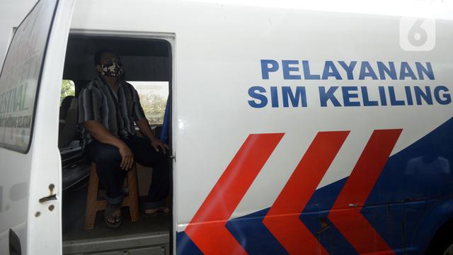 Warga duduk dalam mobil saat mengurus SIM di Pelayanan SIM Keliling, Tangerang Selatan, Banten.